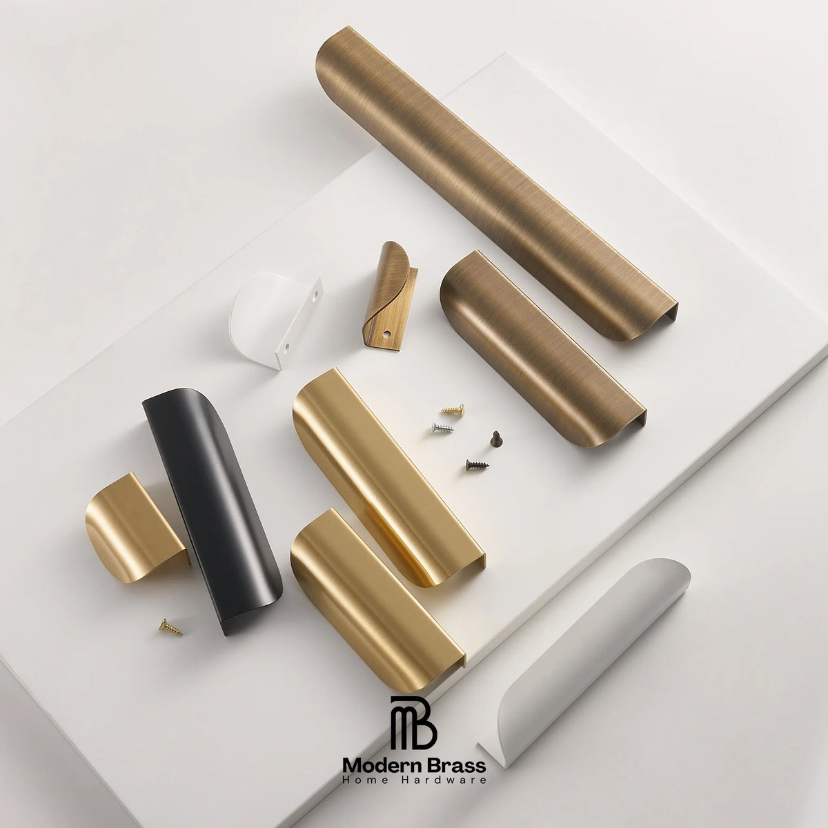 A styled flat-lay of brass hardware pieces, including cylindrical door pulls, handles, and mounting screws, arranged on a white surface with a branded 'Modern Brass' logo at the bottom.