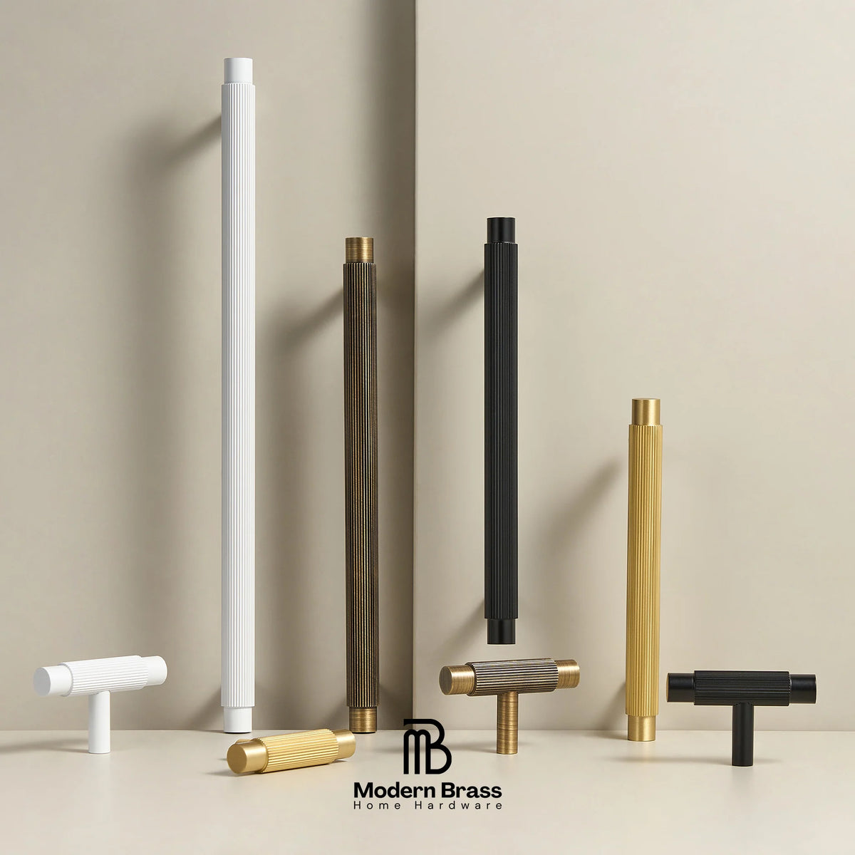 Six modern cylindrical and T-shaped hardware pulls in white, black, and brass finishes arranged on a beige surface against a beige background, with the Modern Brass Home Hardware logo at the bottom.