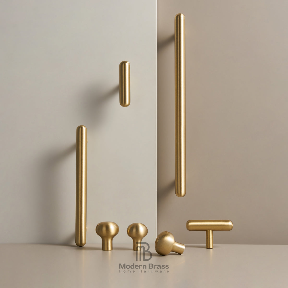 A set of modern brass cabinet knobs in various shapes and sizes, including long bar handles, round ball knobs, and T-bar handles, displayed on a light beige surface against a matching beige background. The brand logo 'Modern Brass Home Hardware' is visible at the bottom.