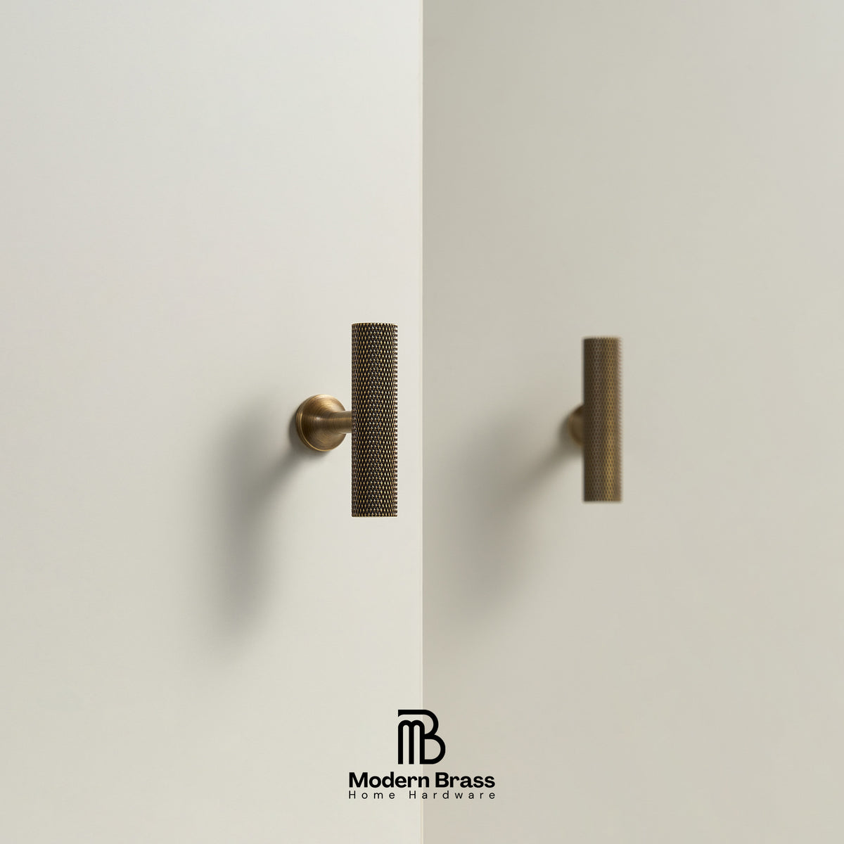 Two modern cylindrical cabinet handles in a textured bronze finish mounted on a minimalist off-white wall, with the Modern Brass logo at the bottom.