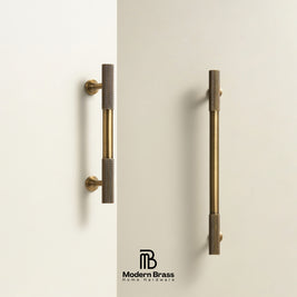 Two modern vertical cabinet handles in brushed brass with knurled textured end caps, mounted on a clean off-white wall. The Modern Brass logo is visible at the bottom.