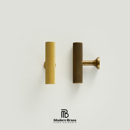 Two modern cylindrical cabinet pulls with a textured honeycomb finish, shown side-by-side on a light gray background. One is a bright gold brass and the other is a darker bronze.