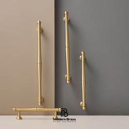 Gold handles on a wall with 'Modern Brass' branding.