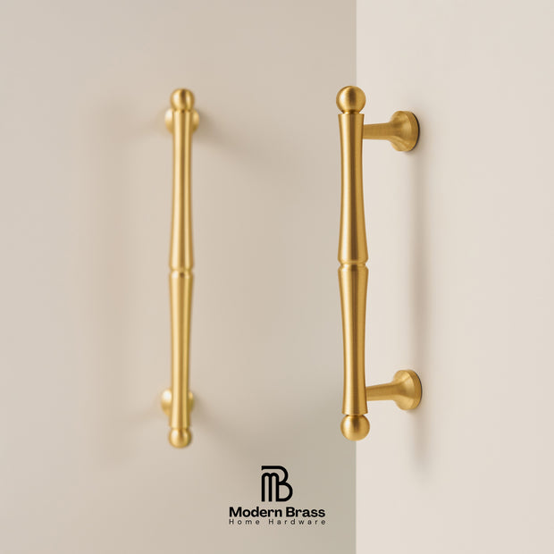 Gold cabinet handles on a beige background with 'Modern Brass' branding.