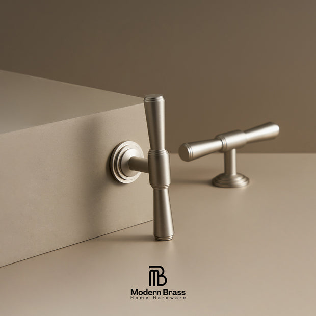 Metallic door handles on a beige surface with 'Modern Brass' branding.