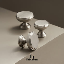 Three metallic cabinet knobs on a gradient background with 'Modern Brass' branding.