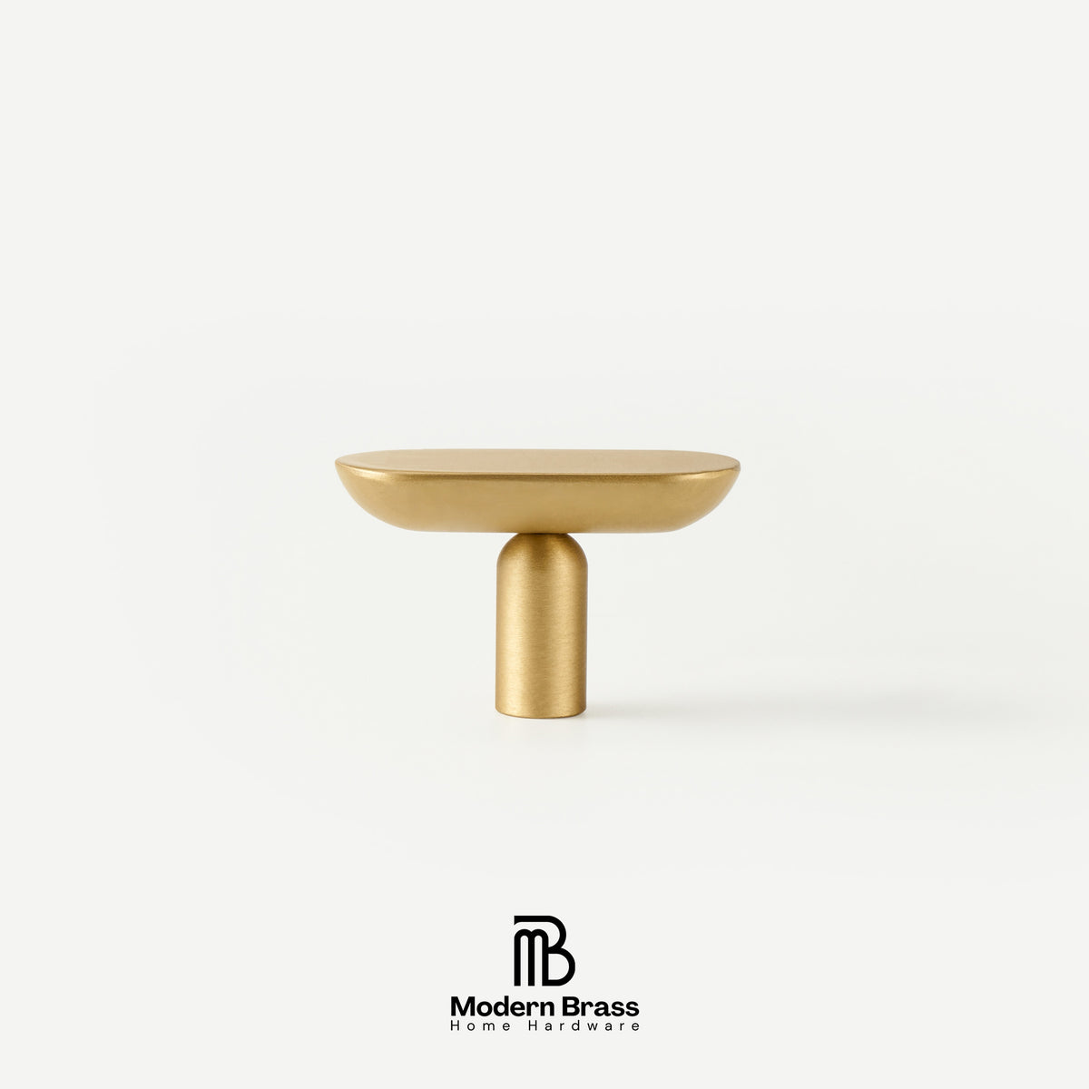Flat lay display of capsule-shaped solid brass drawer handles and matching pill-profile T-knobs