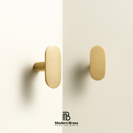 Modern Brass Home Hardware logo displayed below flat oval solid brass handles and knobs lineup