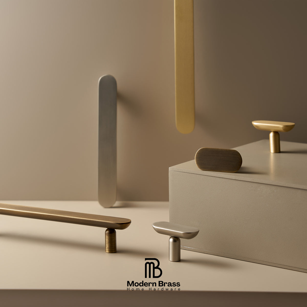 A styled product display of modern brass and silver cabinet knobs and pulls on a minimalist beige background with geometric props. The Modern Brass logo is visible at the bottom.