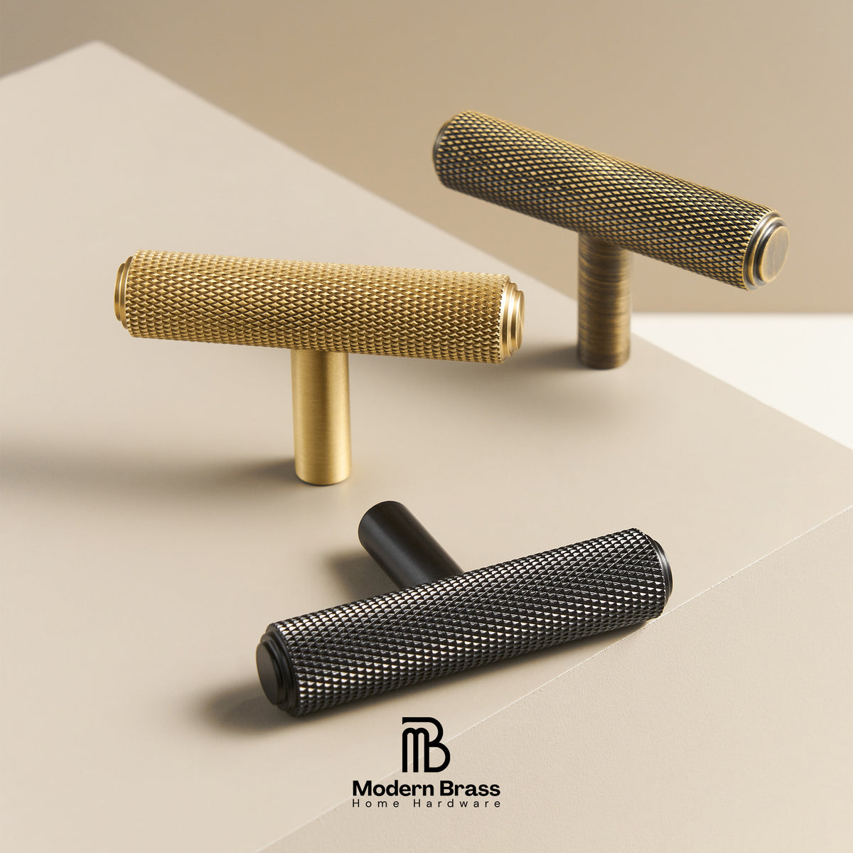 Three cylindrical cabinet knobs with textured mesh-like surfaces in gold, black, and bronze finishes, arranged on a clean beige surface. The Modern Brass Home Hardware logo appears at the bottom.