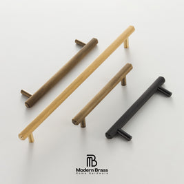 Four modern cylindrical cabinet knobs with textured mesh-like surfaces in gold, bronze, and black finishes, arranged diagonally on a clean white background with the Modern Brass logo at the bottom.