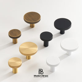 A set of modern cabinet knobs in brushed brass, black, and white, arranged on a clean white background with the Modern Brass Home Hardware logo at the bottom.