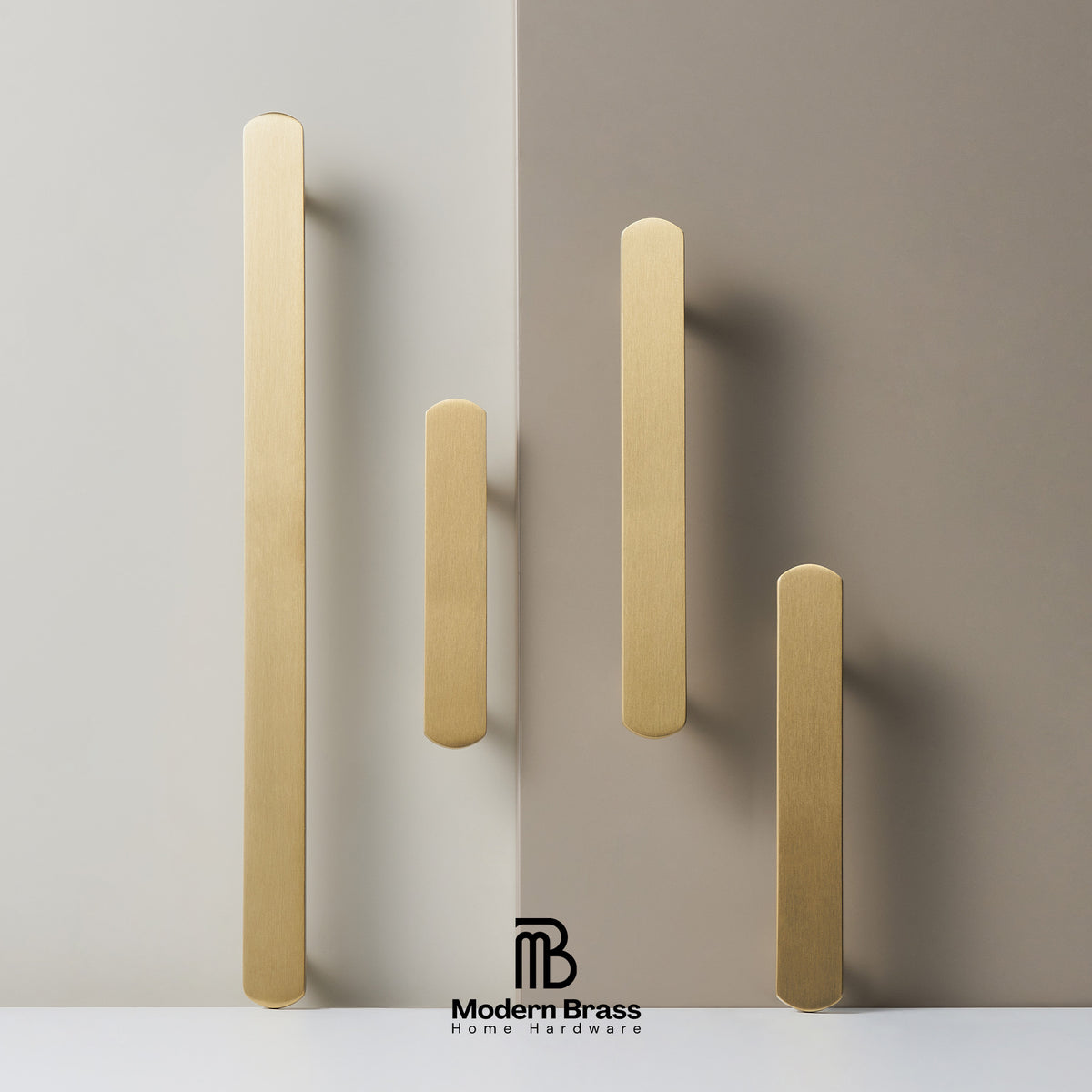 Four brushed brass cabinet handles in different heights, displayed on a split beige and taupe background with the Modern Brass logo at the bottom.