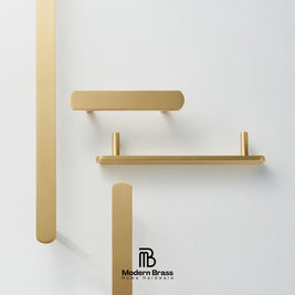 Three round cabinet knobs in black, matte brass, and brushed brass are arranged on a light beige surface against a warm beige background. The Modern Brass logo is visible at the bottom.
