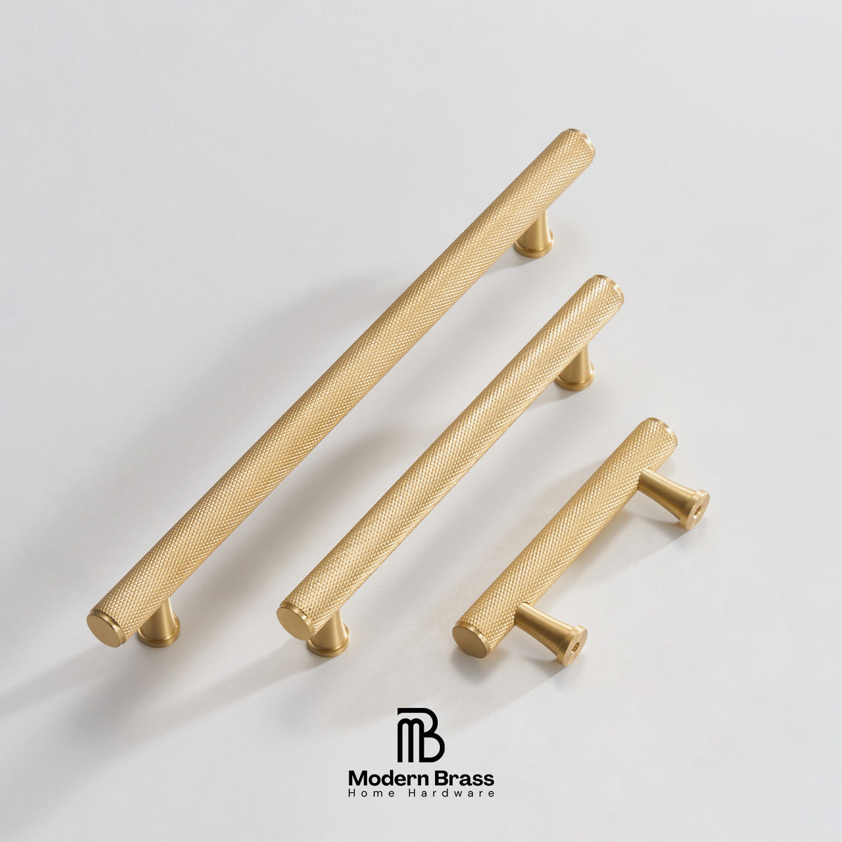 Three brass cabinet knobs in different sizes arranged diagonally on a light gray background, with the Modern Brass logo at the bottom.