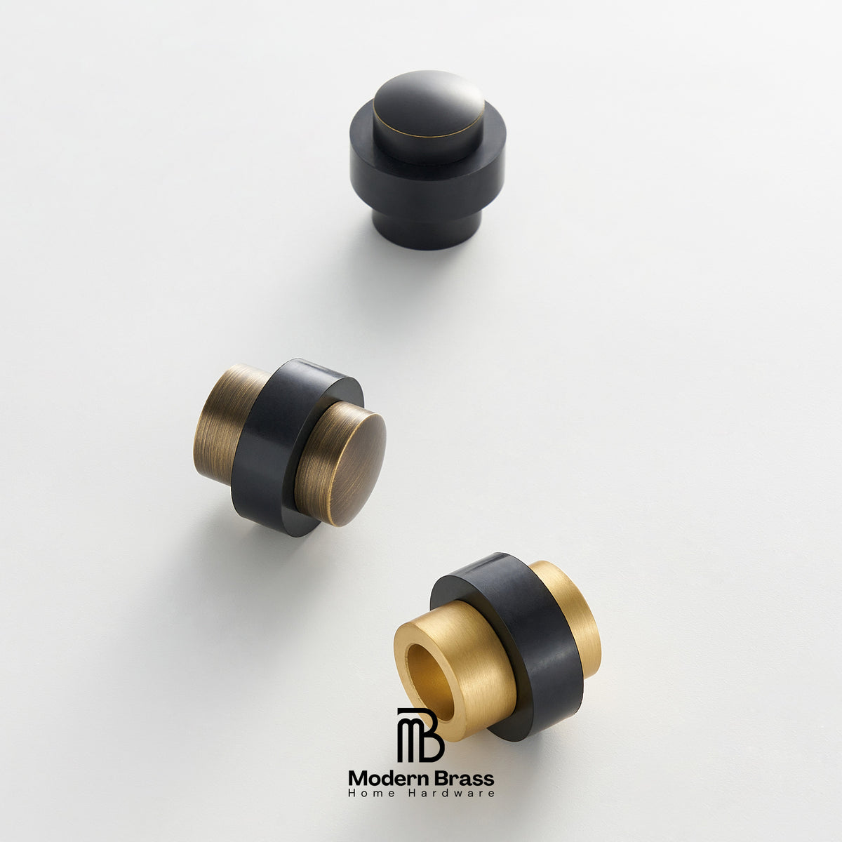 Three modern cylindrical cabinet knobs in matte black and brushed brass finish, arranged on a clean white background with the Modern Brass logo at the bottom.