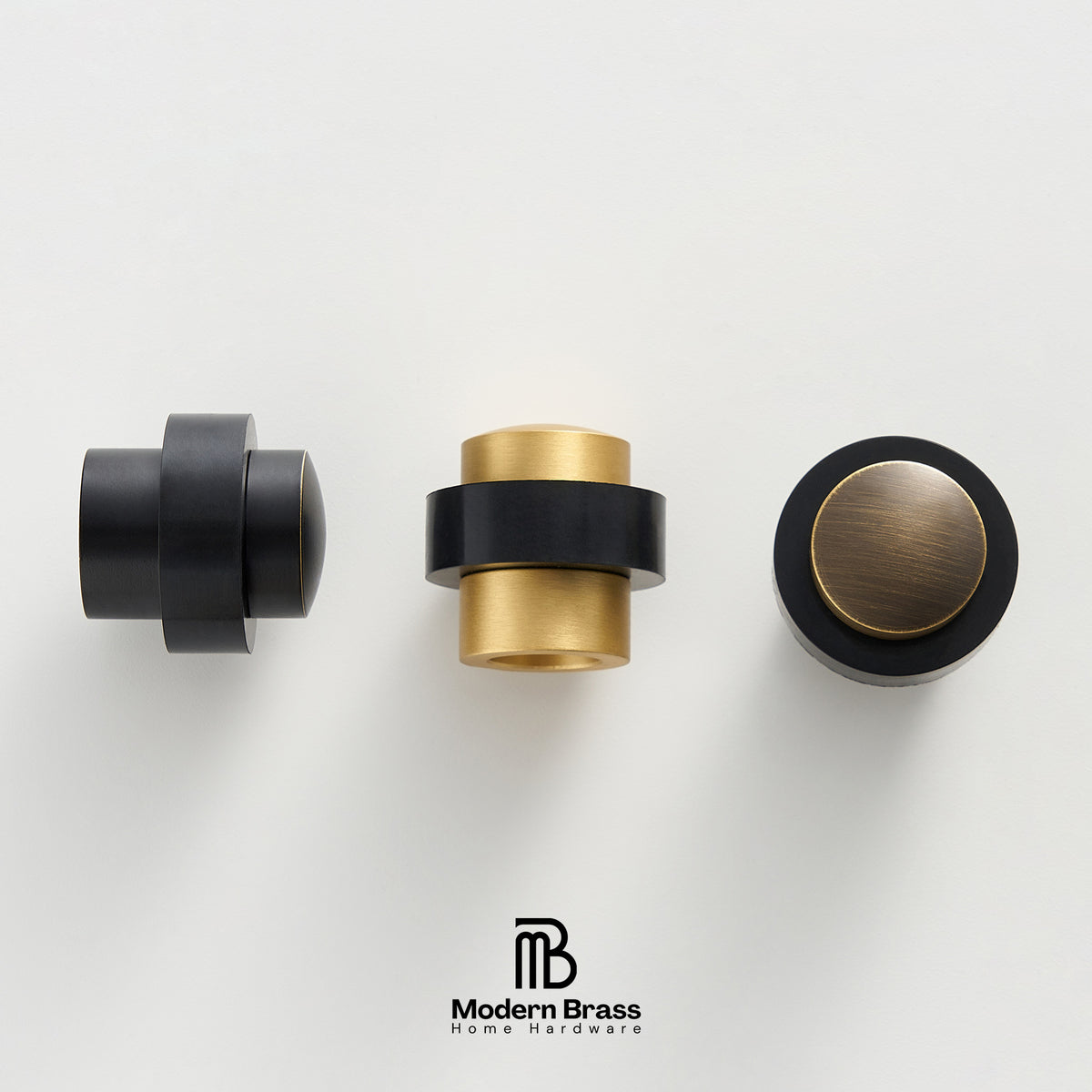 Three modern brass home hardware knobs in black and brushed gold finishes, displayed on a clean white background with the Modern Brass logo at the bottom.
