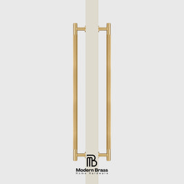 A pair of modern vertical brass door handles with a polished gold finish, shown on a light gray background with a vertical beige handle grip in the center and the 'Modern Brass Home Hardware' logo at the bottom.
