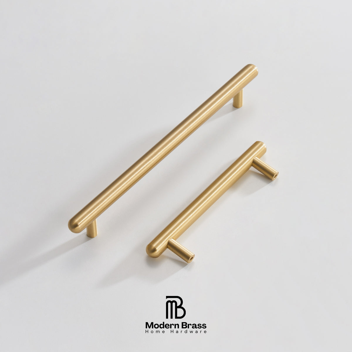 Three round cabinet knobs in black, matte brass, and brushed brass are arranged on a light beige surface against a warm beige background. The Modern Brass logo is visible at the bottom.