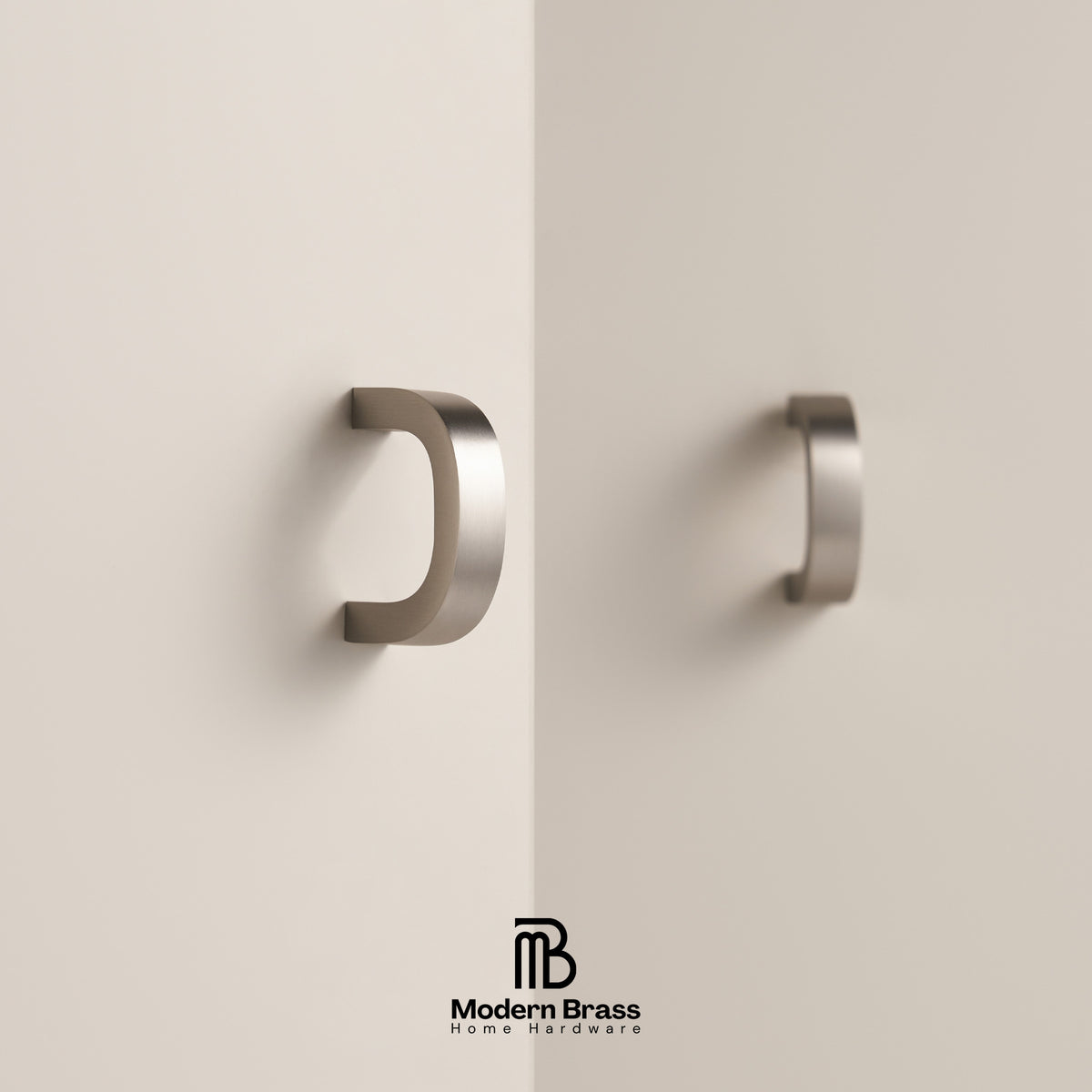 Two modern C-shaped brushed brass cabinet handles mounted on a minimalist beige wall, with the Modern Brass Home Hardware logo at the bottom.
