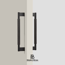 Two matte black cylindrical cabinet handles with rectangular mounting brackets, shown on a split beige and light gray background with the Modern Brass logo at the bottom.