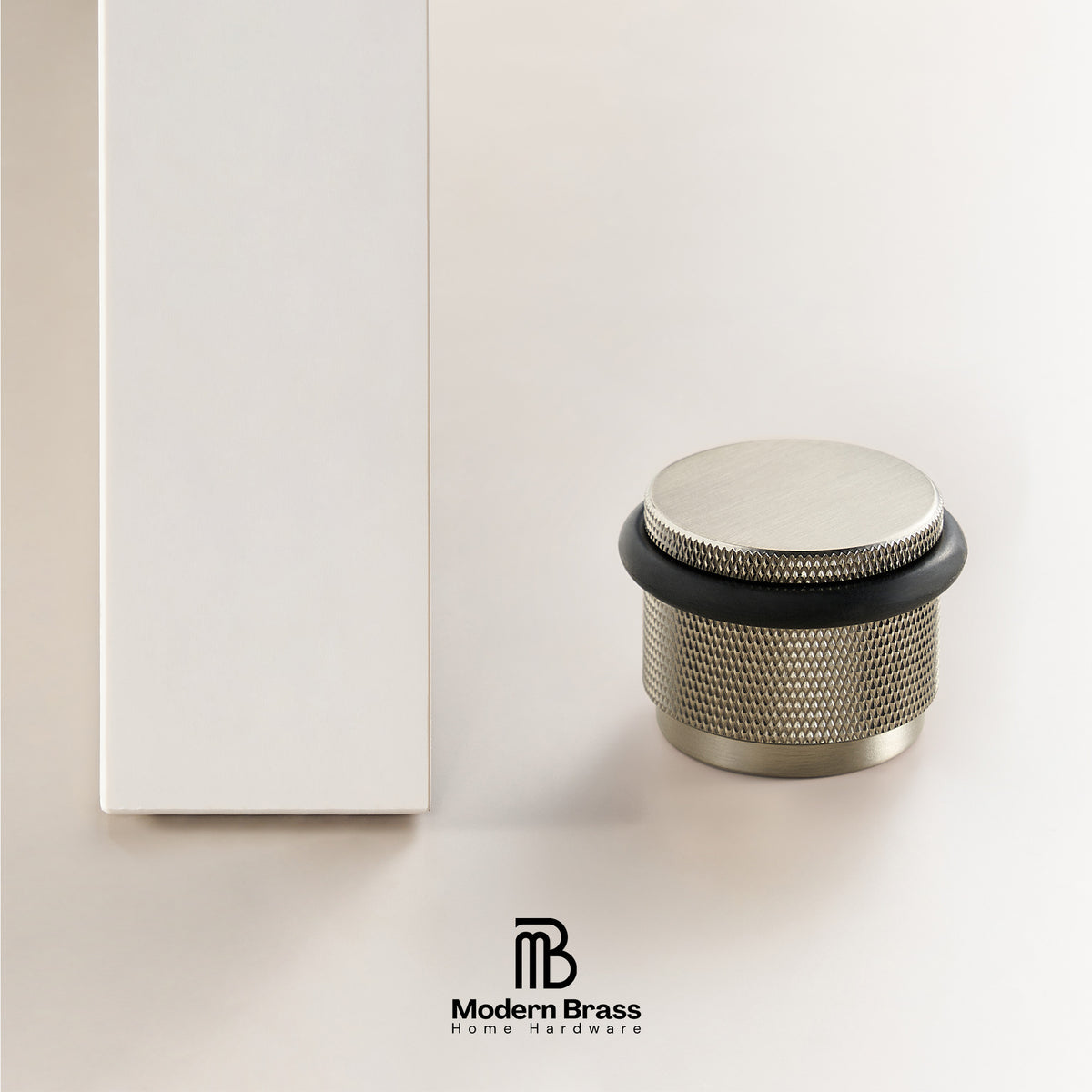 A brushed brass cylindrical home hardware piece with a knurled mesh texture and a black rubber gasket, shown next to its white packaging box on a clean white background. The Modern Brass logo is visible at the bottom.