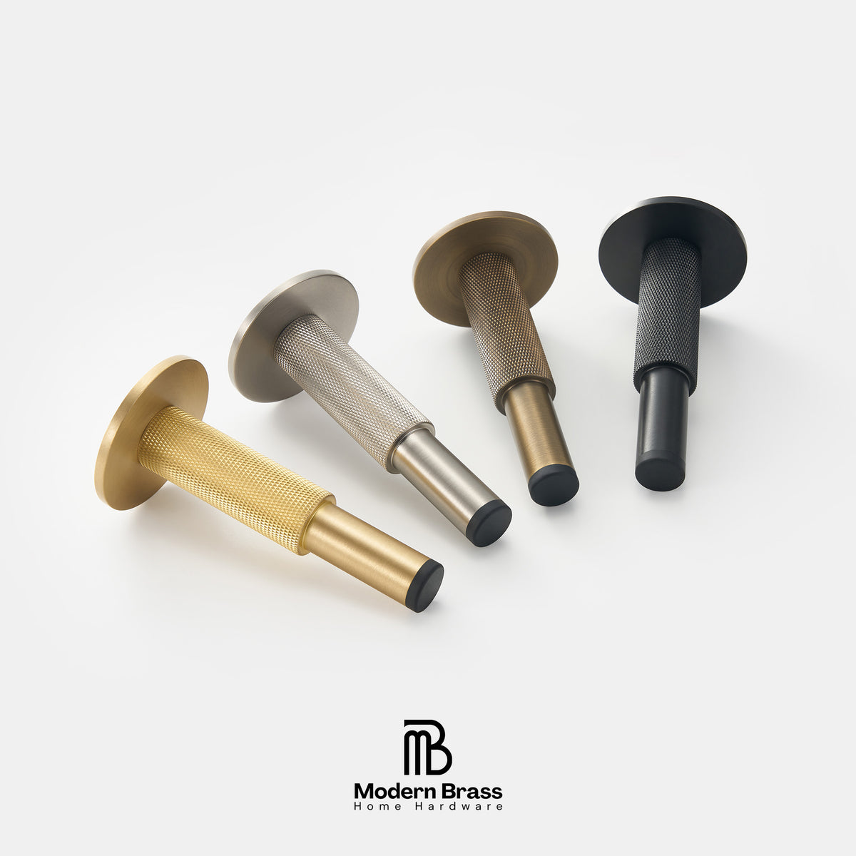 Four modern brass wall anchors in gold, silver, bronze, and black finishes, arranged diagonally on a clean white background with the Modern Brass logo at the bottom.