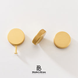 Three brass cabinet knobs in a gold finish, shown from different angles on a clean white background with the Modern Brass logo at the bottom.