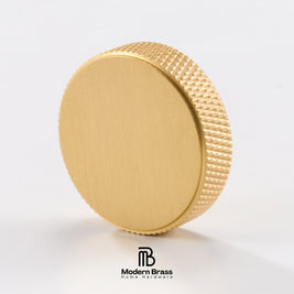A round brushed brass cap or knob with a textured knurled edge, shown on a clean white background with the Modern Brass logo at the bottom.