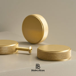 Four-piece brass cabinet hardware set including two long vertical bar handles, one short vertical bar handle, one horizontal pull handle, and three round cabinet knobs, displayed on a white surface against a beige background. The Modern Brass logo is visible at the bottom.