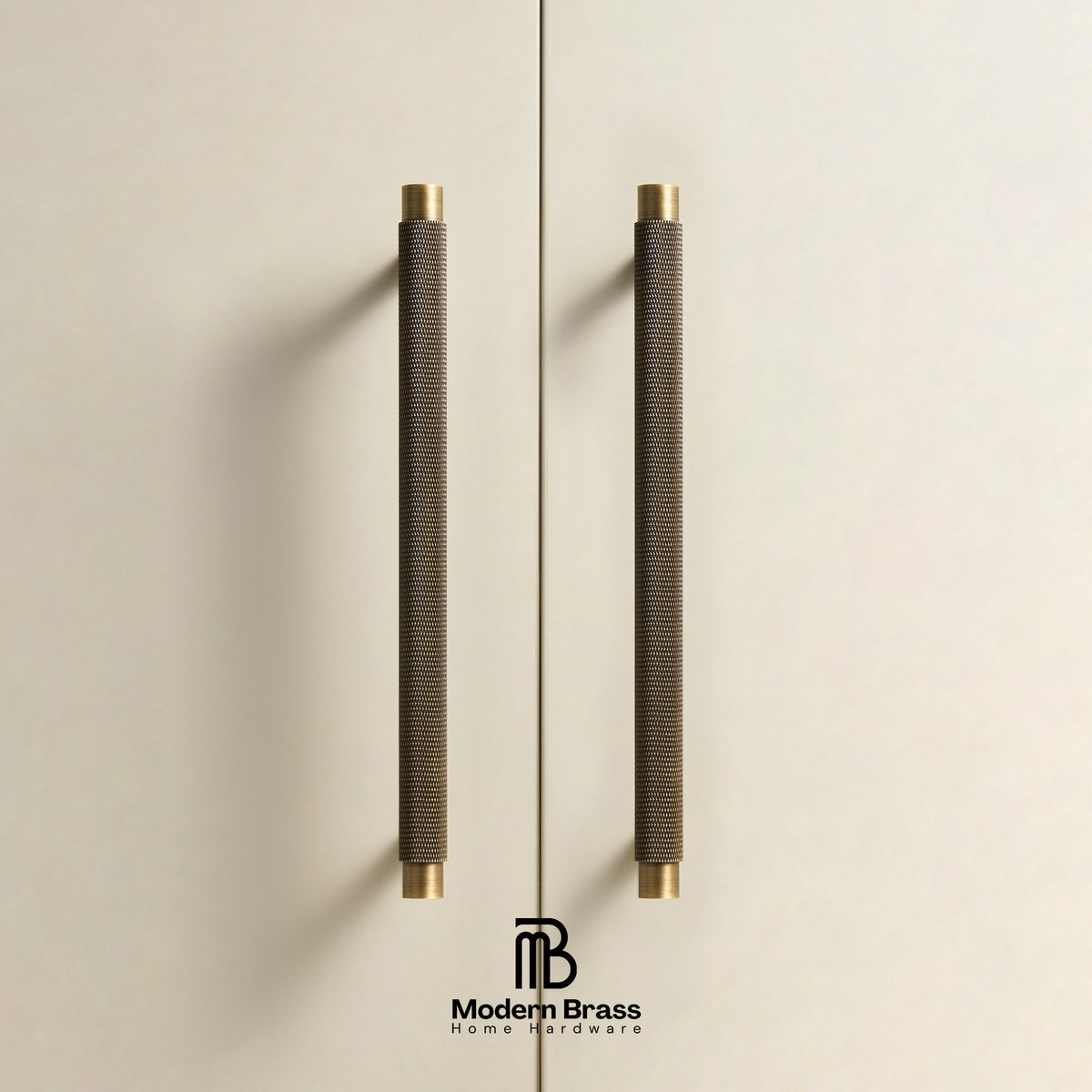 Two long cylindrical cabinet handles with a dark textured wrap and brass end caps, mounted on a light beige door. The Modern Brass logo is visible at the bottom.