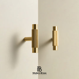 Two modern cylindrical cabinet pulls in brushed brass, one mounted on a wall and one hanging, shown against a clean off-white background with the Modern Brass logo at the bottom.