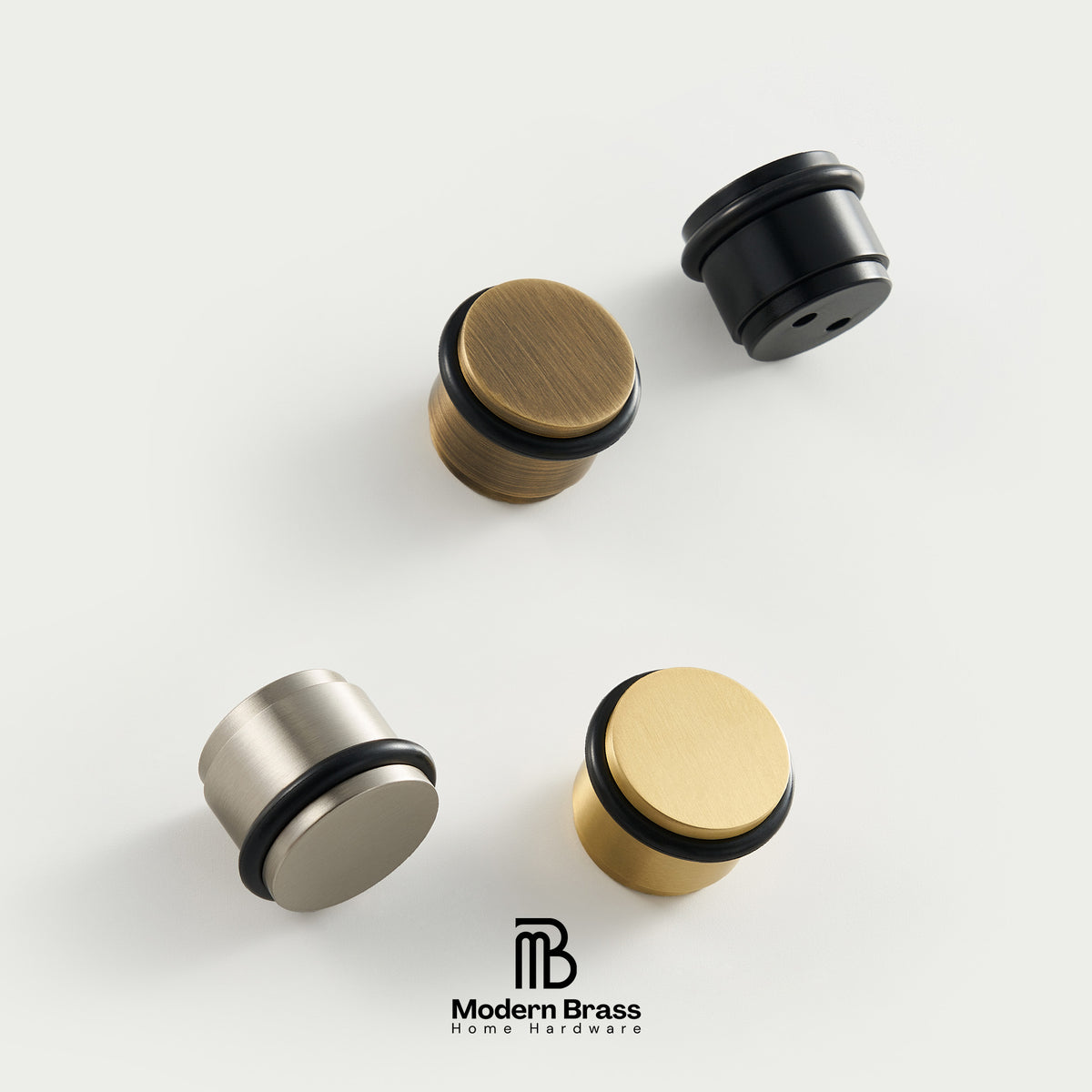 Four modern cylindrical wall hooks in brushed brass, black, and satin nickel finishes, arranged on a clean off-white background with the Modern Brass logo at the bottom.