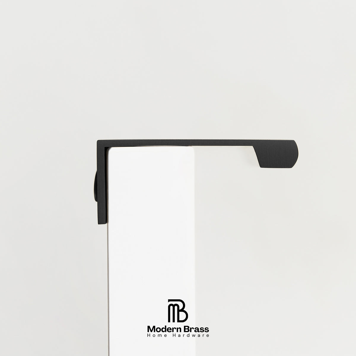 Three round cabinet knobs in black, matte brass, and brushed brass are arranged on a light beige surface against a warm beige background. The Modern Brass logo is visible at the bottom.