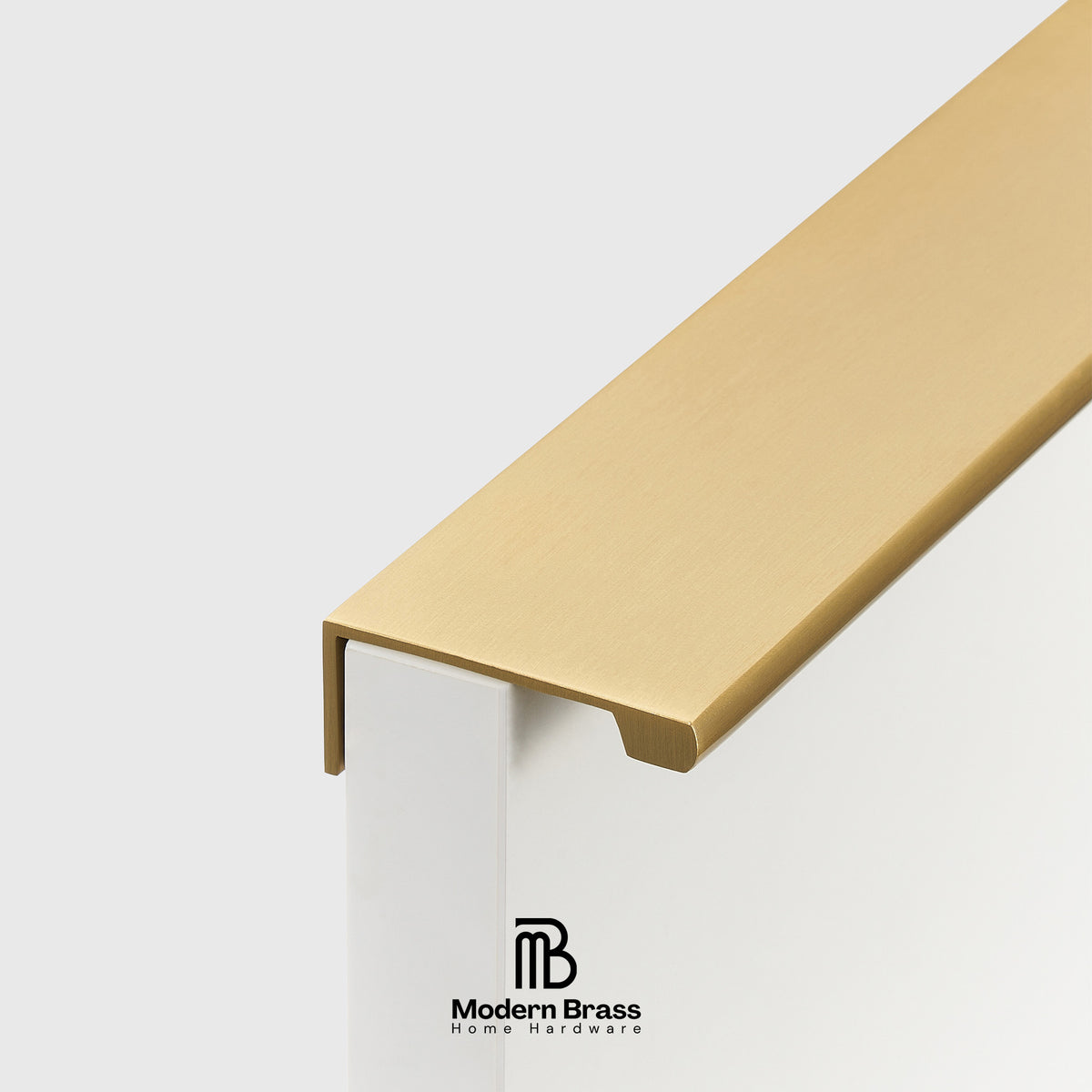 A close-up of a modern L-shaped brass handrail end cap mounted on a white post, with the Modern Brass Home Hardware logo visible at the bottom.