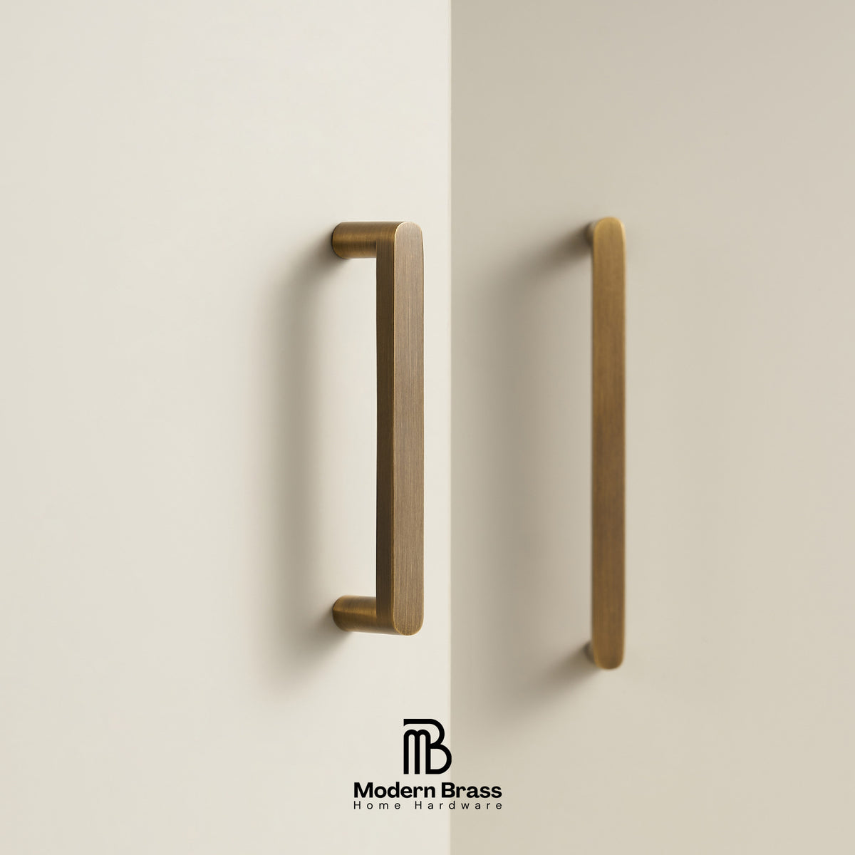 Two brass cabinet handles mounted on a warm off-white wall, with the Modern Brass Home Hardware logo at the bottom.