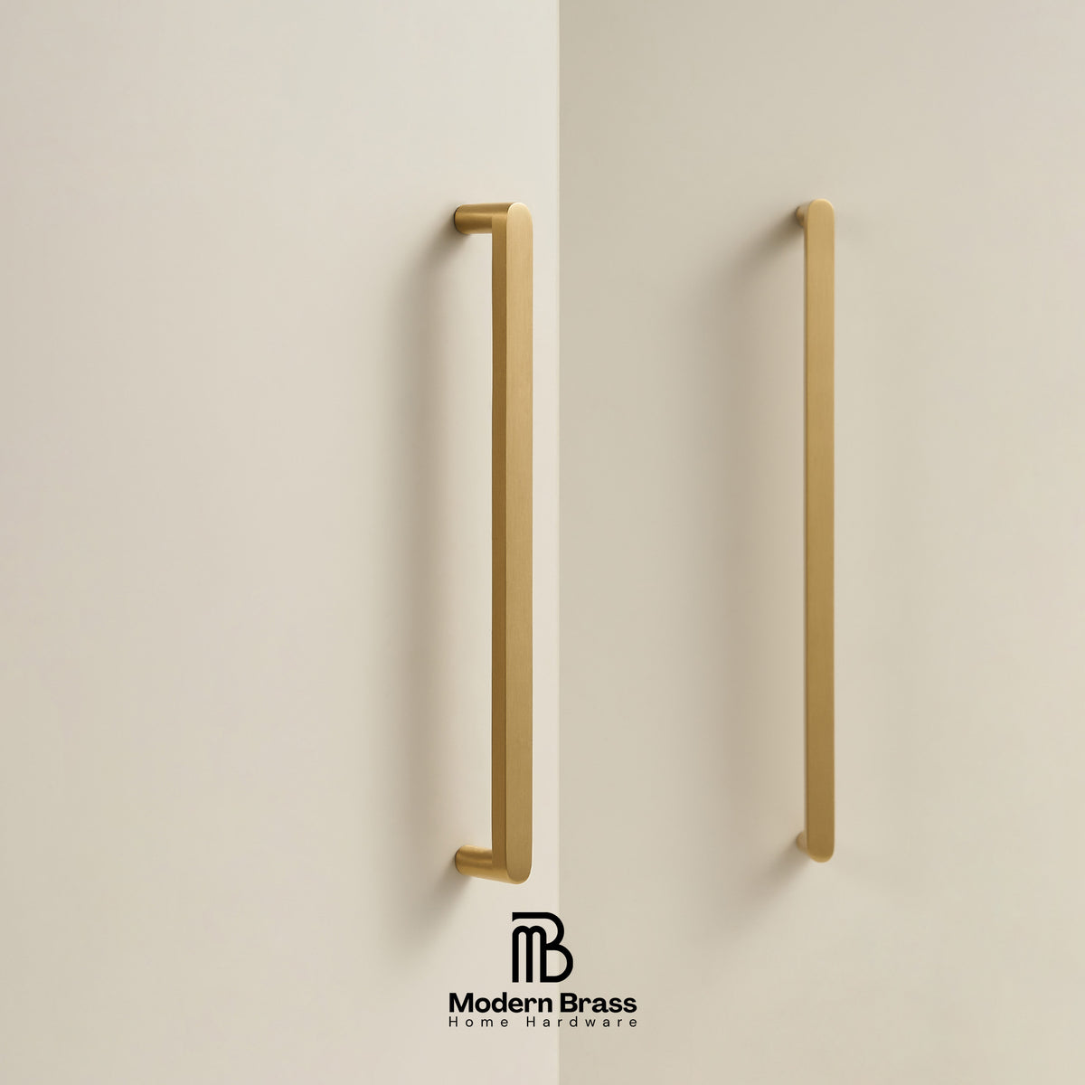Two modern vertical brass cabinet handles mounted on a light beige wall, with the Modern Brass logo at the bottom.