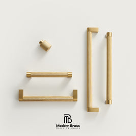 Three round cabinet knobs in black, matte brass, and brushed brass are arranged on a light beige surface against a warm beige background. The Modern Brass logo is visible at the bottom.