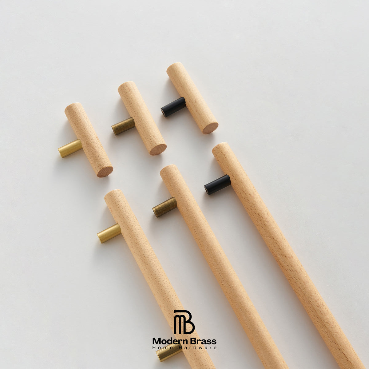 Four-piece brass cabinet hardware set including two long vertical bar handles, two shorter vertical bar handles, and three round knobs, displayed on a white surface against a beige background. The Modern Brass logo is visible at the bottom.